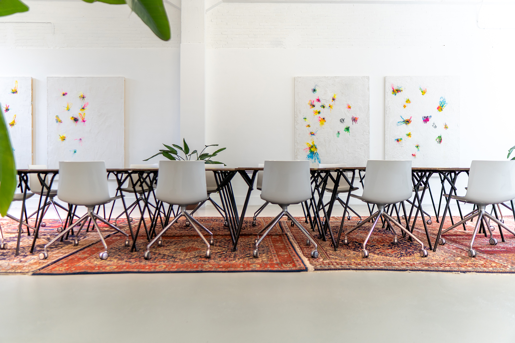 Unieke vergaderlocatie in Rotterdam met een lange vergadertafel en kunst aan de muur in de Dutch Art Room.